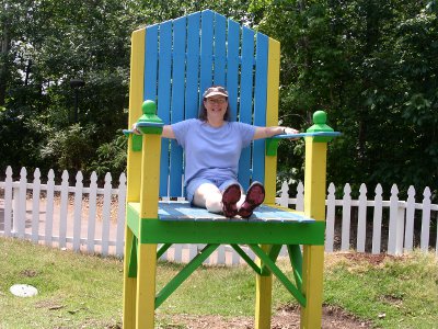 [Me seated in an oversized wooden lawn chair.]